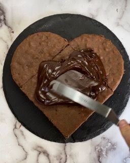 Un biscotto a forma di cuore con crema al cioccolato sopra
