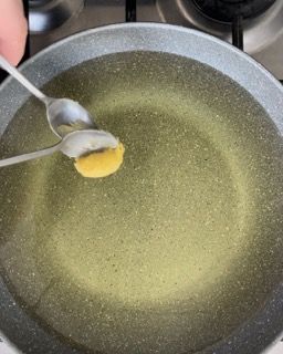 Una persona sta mescolando un liquido in una pentola con un cucchiaio.