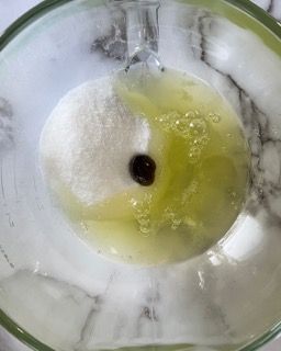 Un primo piano di una ciotola di liquido con un oggetto nero al suo interno.