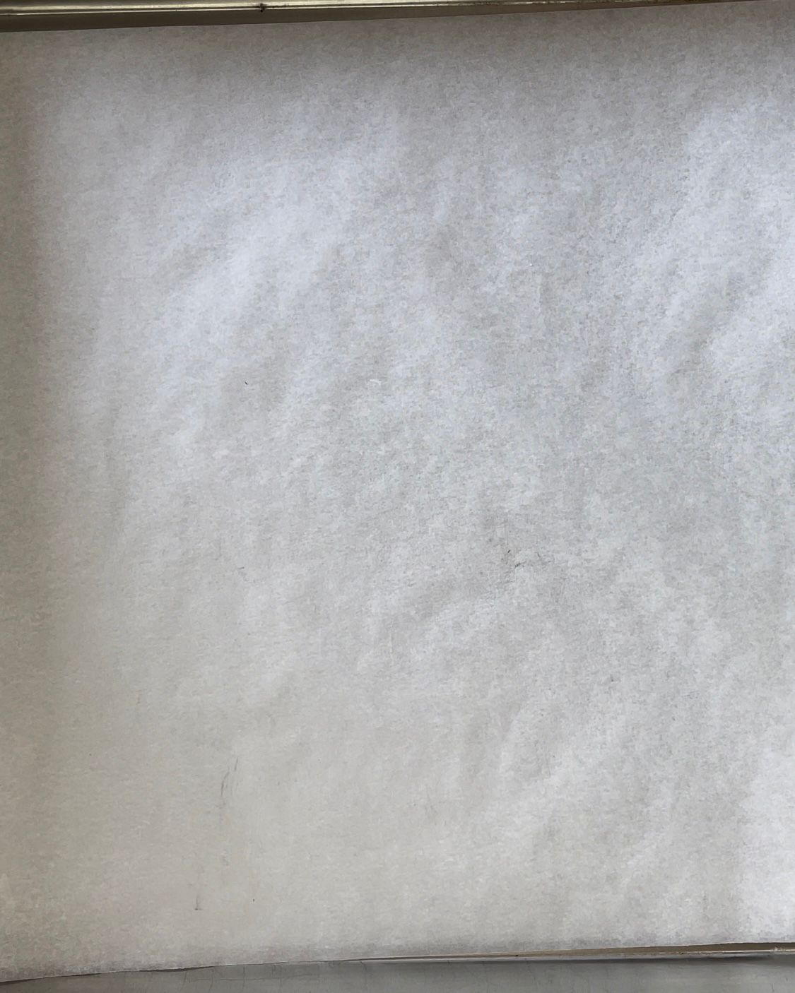 Un pezzo di carta oleata è appoggiato sopra una padella.