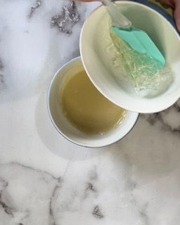 Una persona versa del liquido in una ciotola con una spatola.