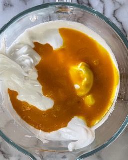 Un primo piano di una ciotola di zuppa con un cucchiaio dentro.
