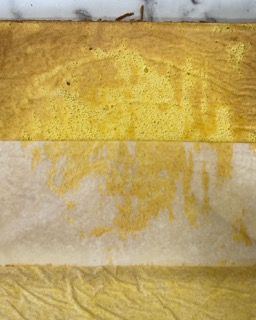 Un primo piano di un pezzo di carta con una macchia gialla.