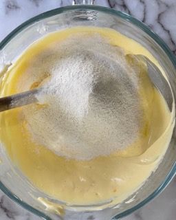 Una ciotola di liquido giallo con un cucchiaio dentro.