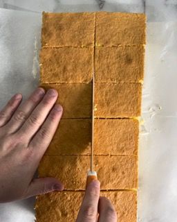 Una persona sta tagliando una fetta di torta in quadrati.