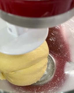 Primo piano di un'impastatrice con una palla di impasto al suo interno.
