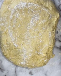 Primo piano di un pezzo di pasta su una superficie di marmo.