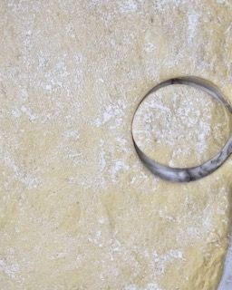 Si usa un anello di metallo per fare un buco in un pezzo di pasta.