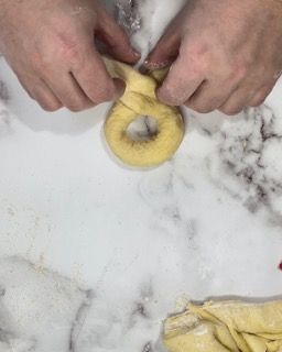Una persona sta preparando una ciambella su un tavolo di marmo.