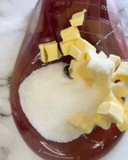 Un becher rosso con burro e zucchero dentro