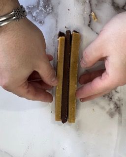 Una persona tiene due pezzi di cibo nelle sue mani.