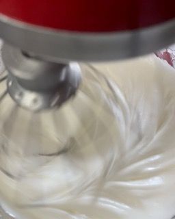Un primo piano di un mixer con panna montata al suo interno.