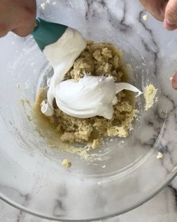 Una persona sta mescolando un impasto in una ciotola con una spatola.