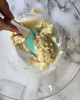 Una persona sta mescolando qualcosa in una ciotola con una spatola.
