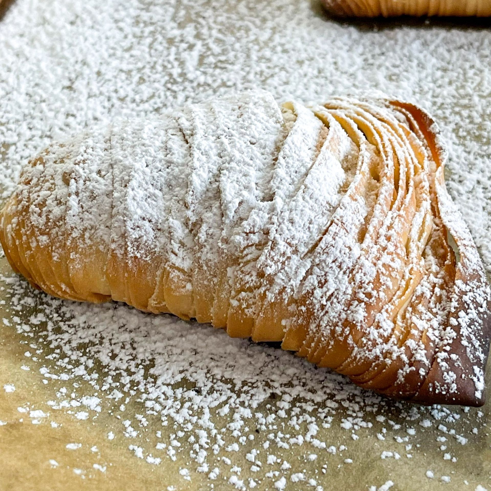 Primo piano di un dolce ricoperto di zucchero a velo su un tavolo.