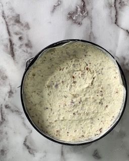 Una ciotola di salsa è appoggiata su una superficie di marmo.