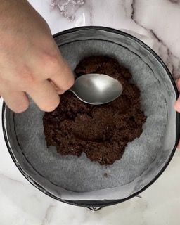Una persona sta usando un cucchiaio per mescolare l'impasto dei brownie in una padella.