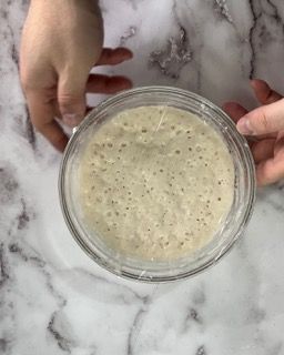 Una persona tiene in mano una ciotola di cibo su un tavolo.
