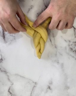 Una persona sta attorcigliando un pezzo di pasta su un bancone di marmo.