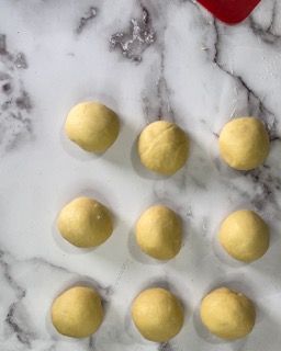 Un mucchio di palline gialle sono appoggiate su una superficie di marmo.