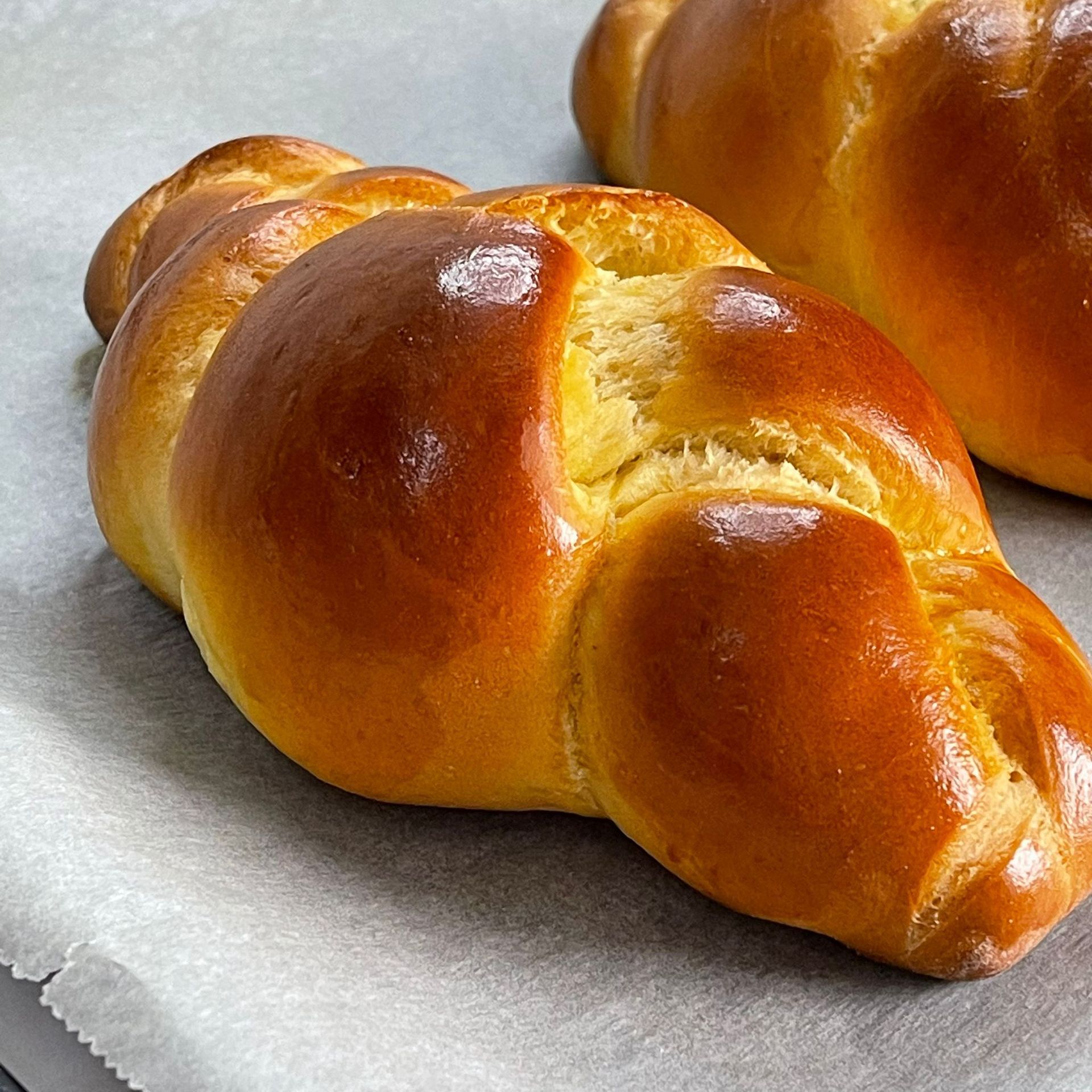Due pagnotte di pane sono appoggiate su un pezzo di carta oleata