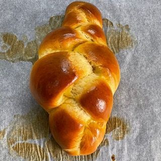 Una pagnotta di pane è appoggiata su un pezzo di carta oleata