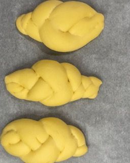 Tre rotoli intrecciati sono appoggiati su un pezzo di carta oleata