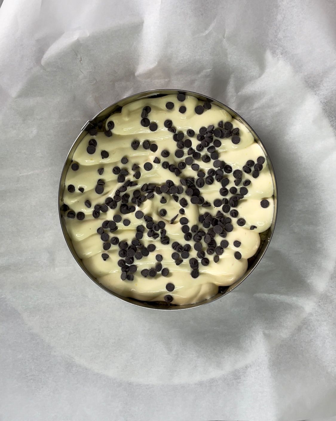 Una ciotola di cibo con gocce di cioccolato sopra è appoggiata su un pezzo di carta oleata.