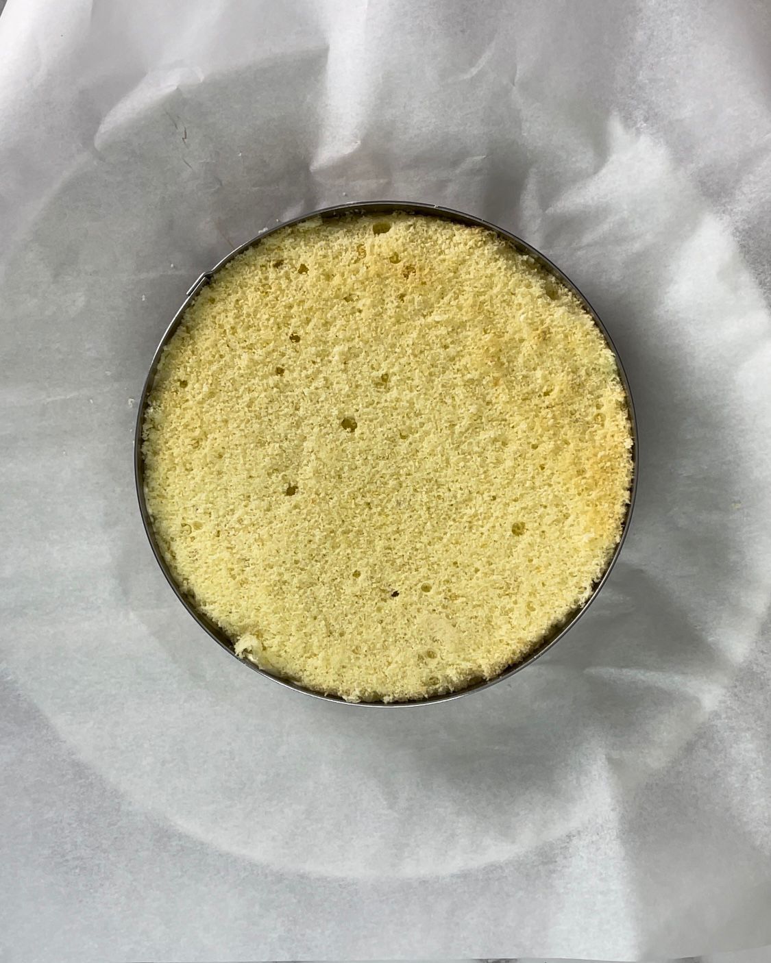 Una torta rotonda appoggiata su un pezzo di carta oleata.