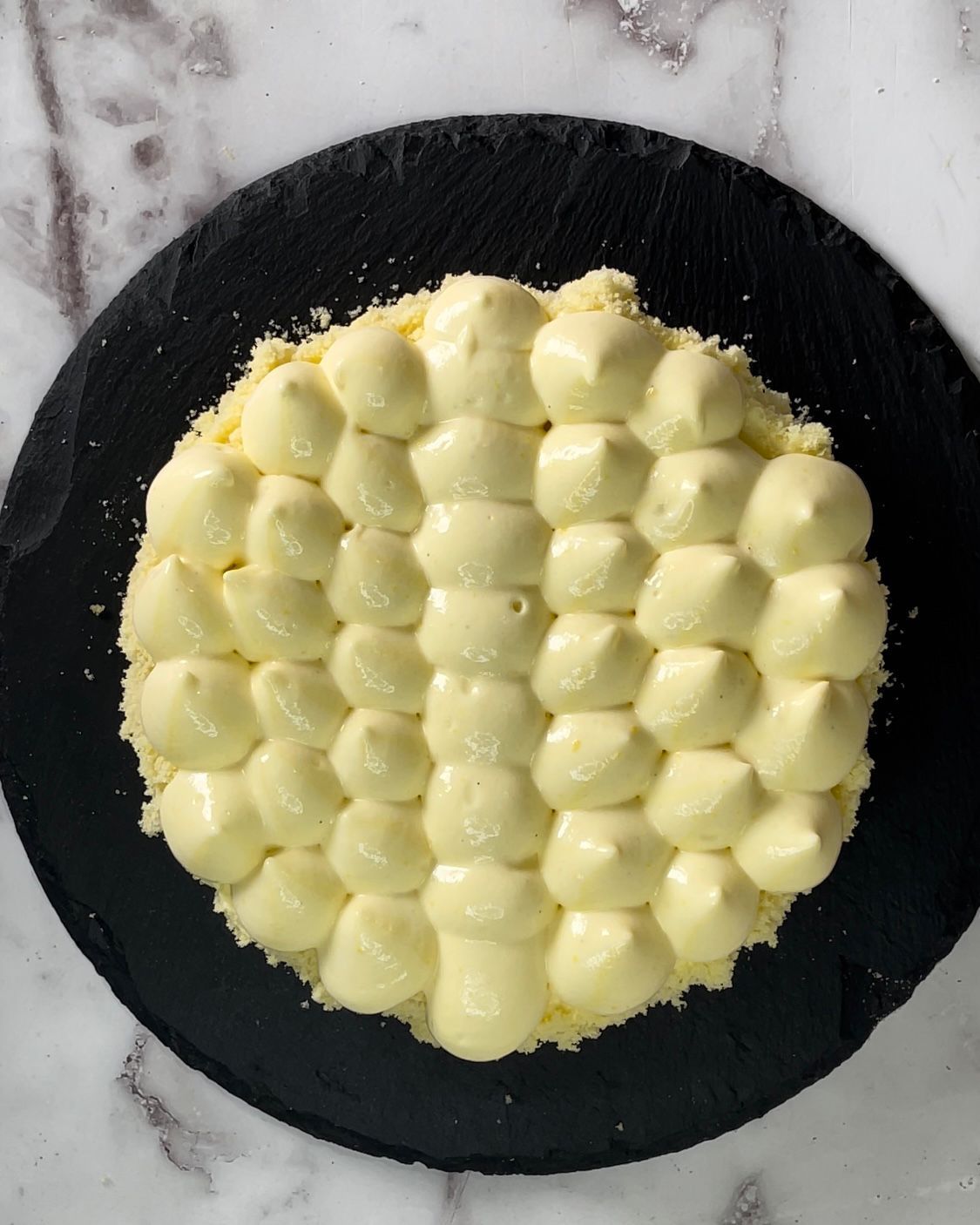 Una torta con glassa bianca su un piatto nero