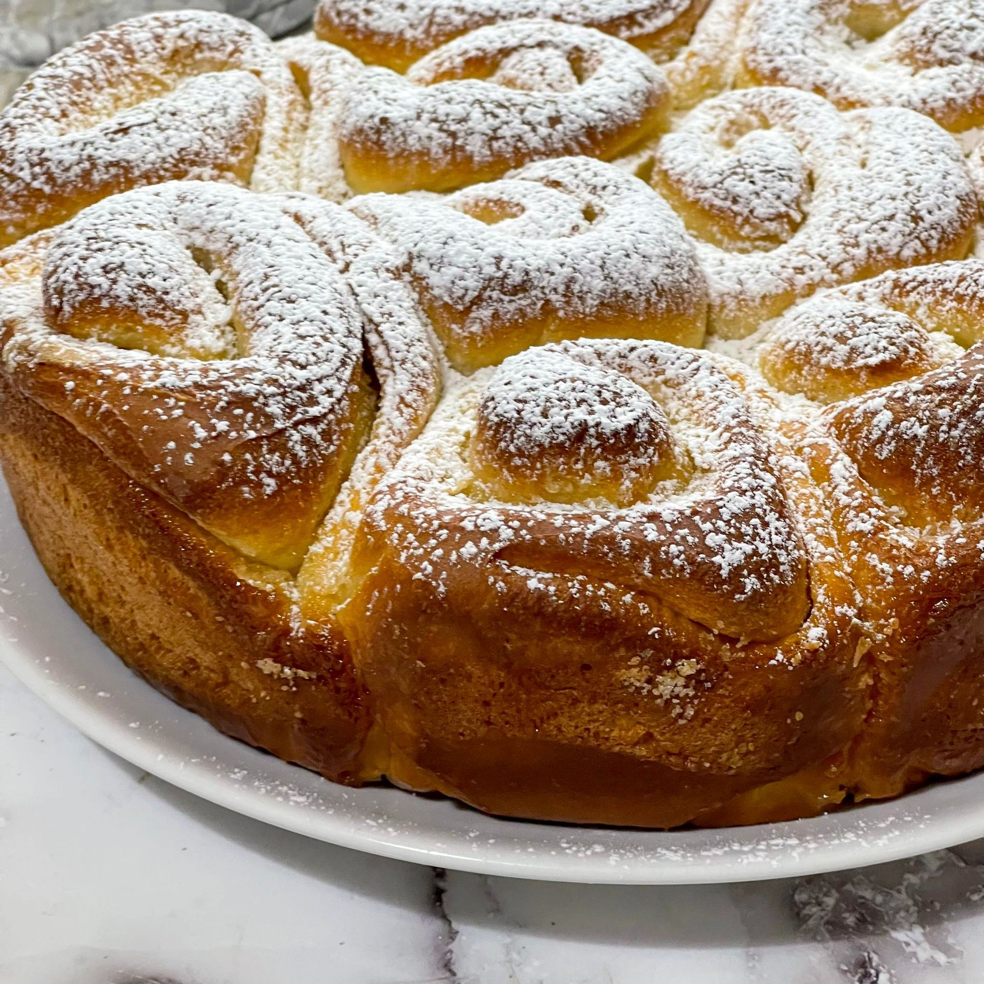 Un primo piano di una torta con zucchero a velo sopra, su un piatto.