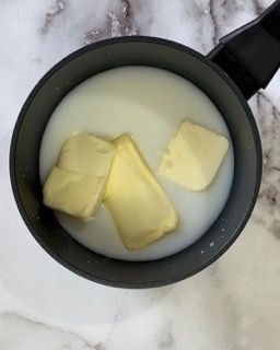 Una pentola di latte e burro su un tavolo.