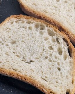 Due fette di pane sono appoggiate su una superficie nera