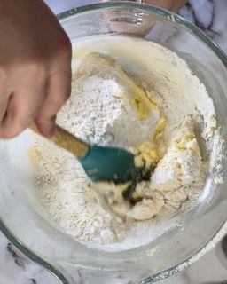 Una persona mescola gli ingredienti in una ciotola con una spatola.