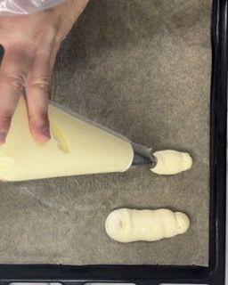 Una persona sta versando la glassa in una sac à poche su un vassoio.