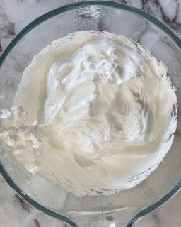 Primo piano di una ciotola di panna montata su un tavolo.