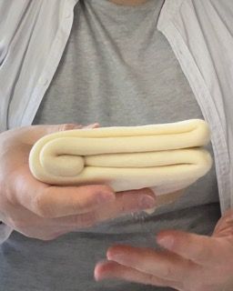 Una persona tiene in mano un pezzo di pasta.