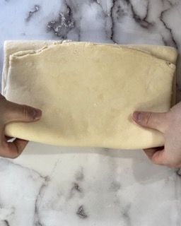 Una persona tiene in mano un pezzo di pasta.