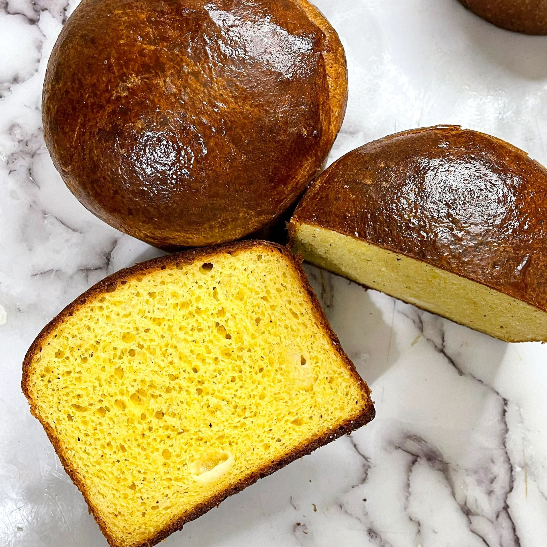Tre fette di pane sono appoggiate su una superficie di marmo.