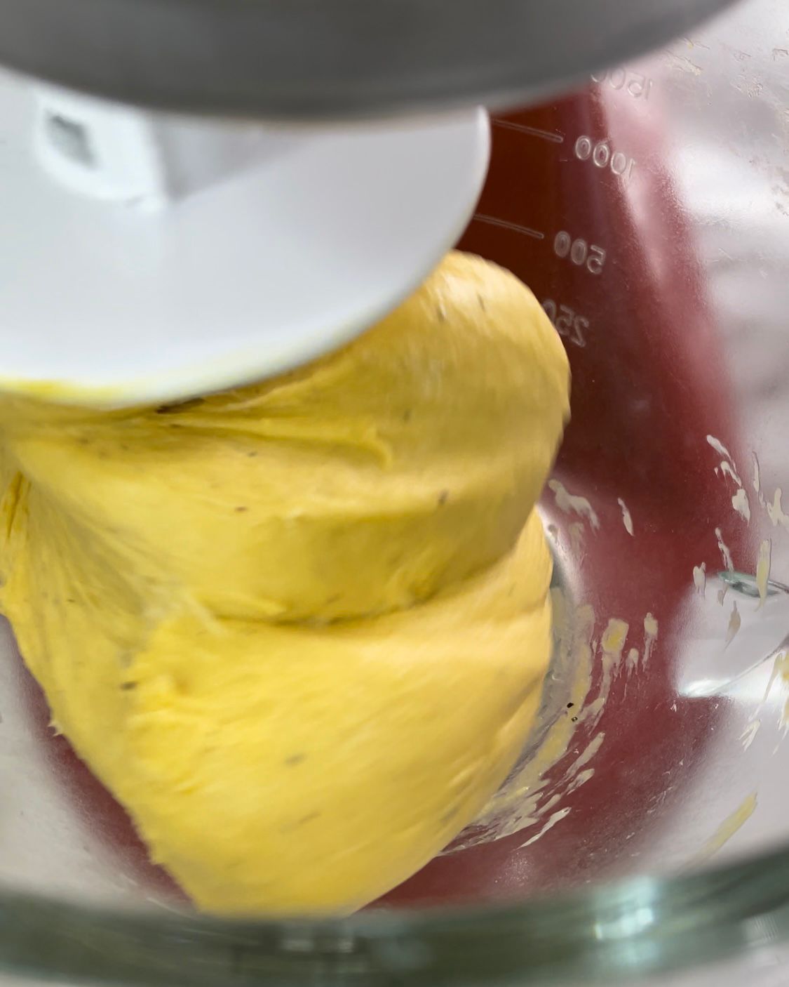 Una persona sta mescolando una sostanza gialla in una tazza graduata