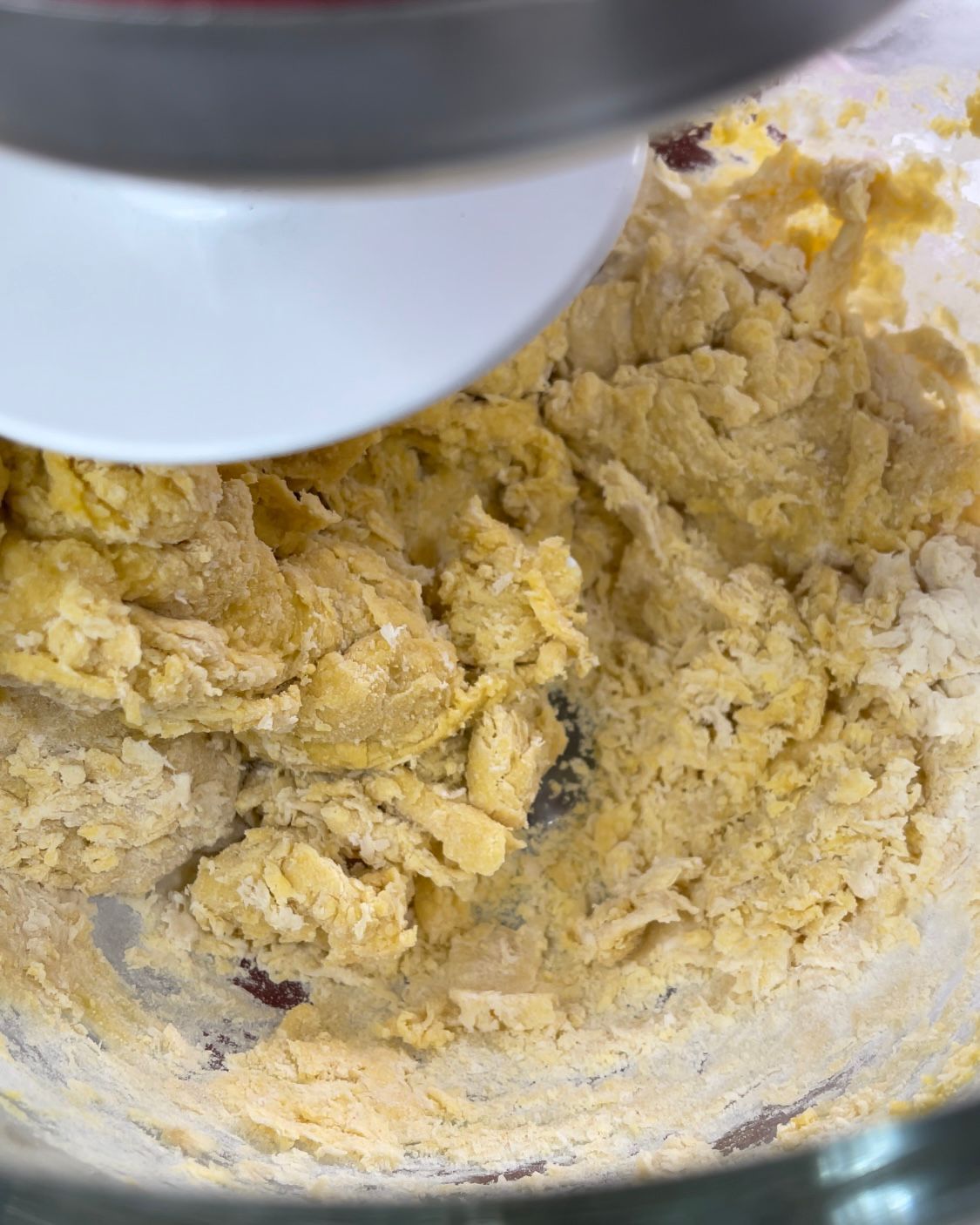 Primo piano di un'impastatrice che mescola un impasto in una ciotola.