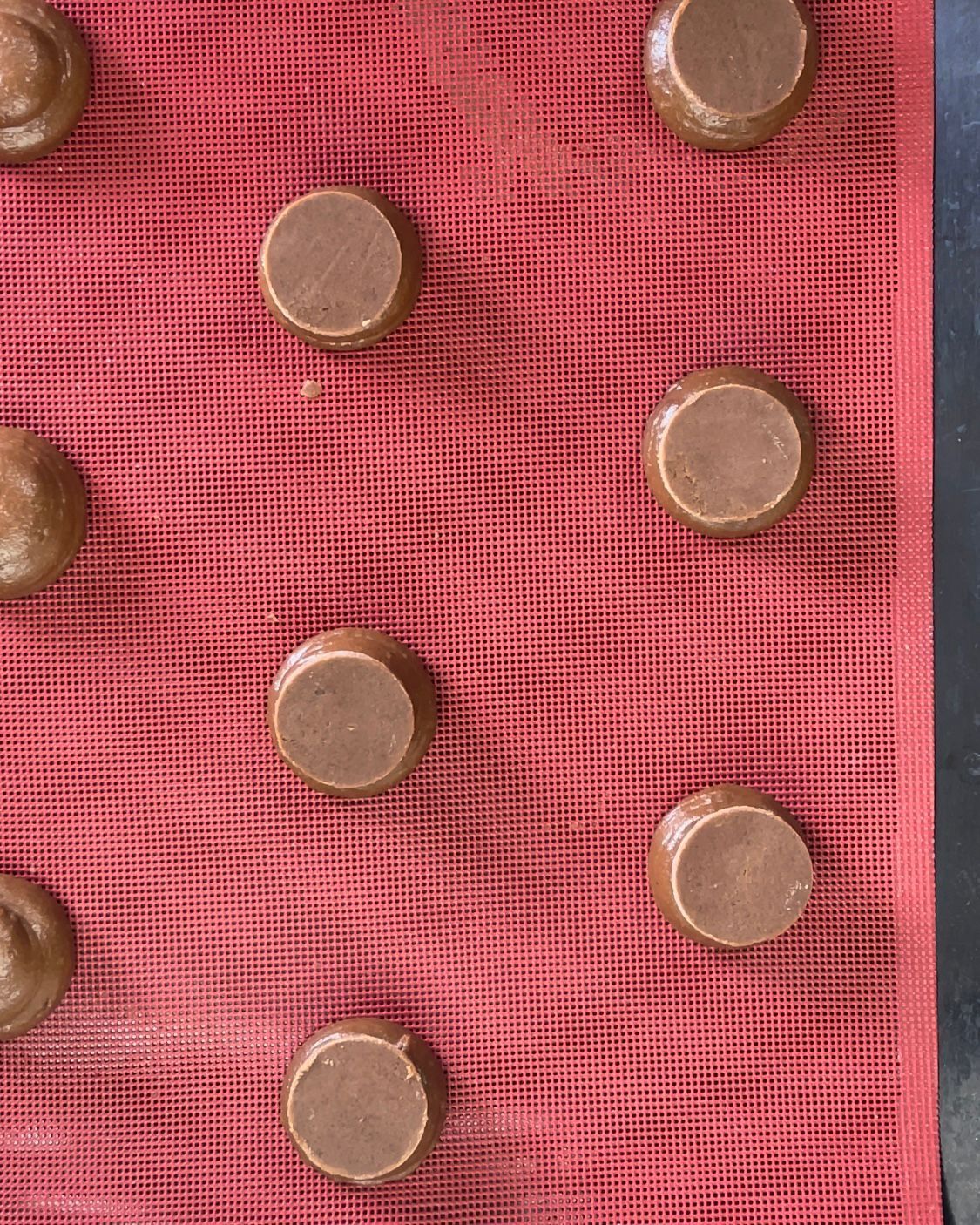 Un mucchio di bottoni di cioccolato sono appoggiati su un tappetino rosso.
