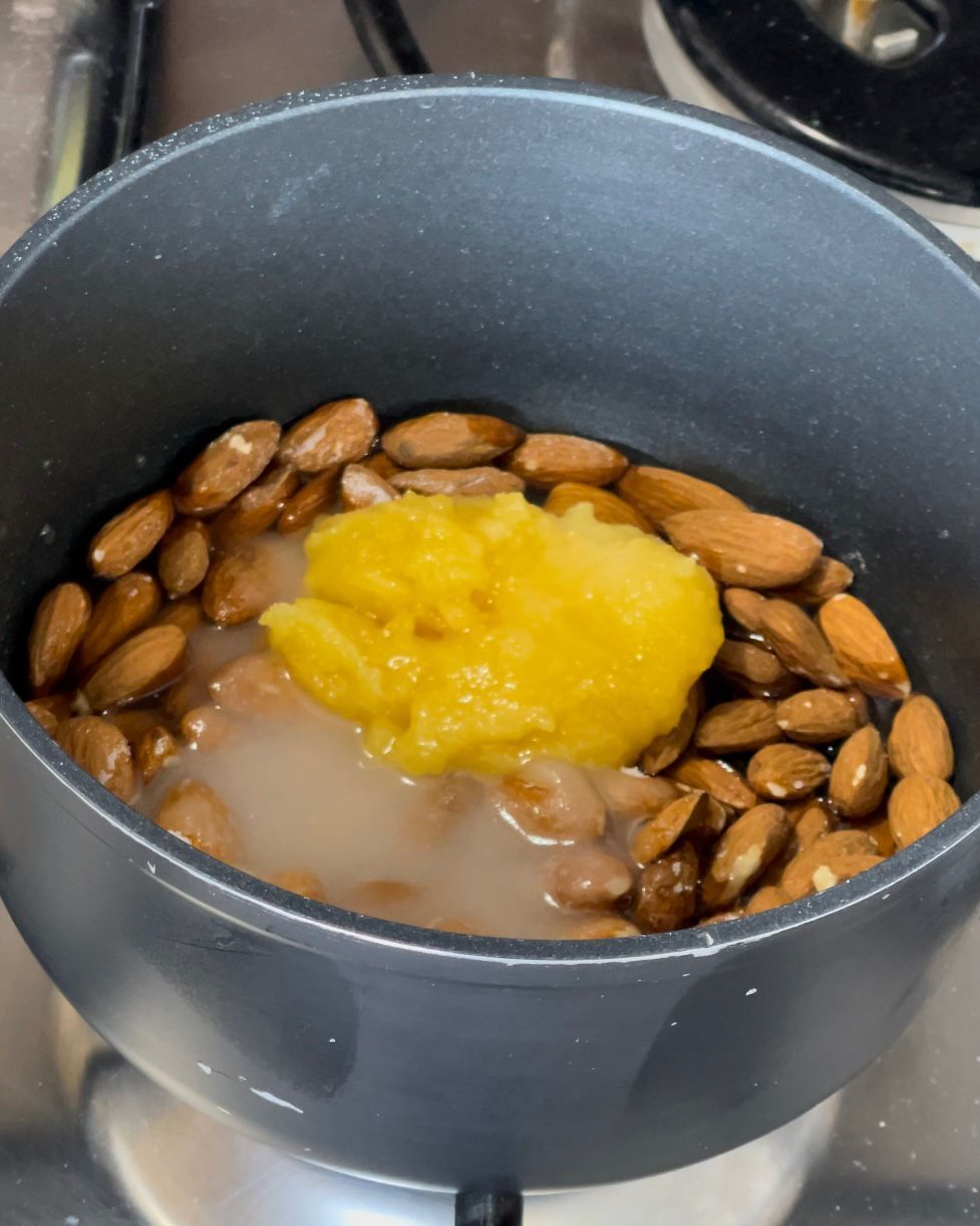 Una pentola piena di mandorle e un liquido giallo