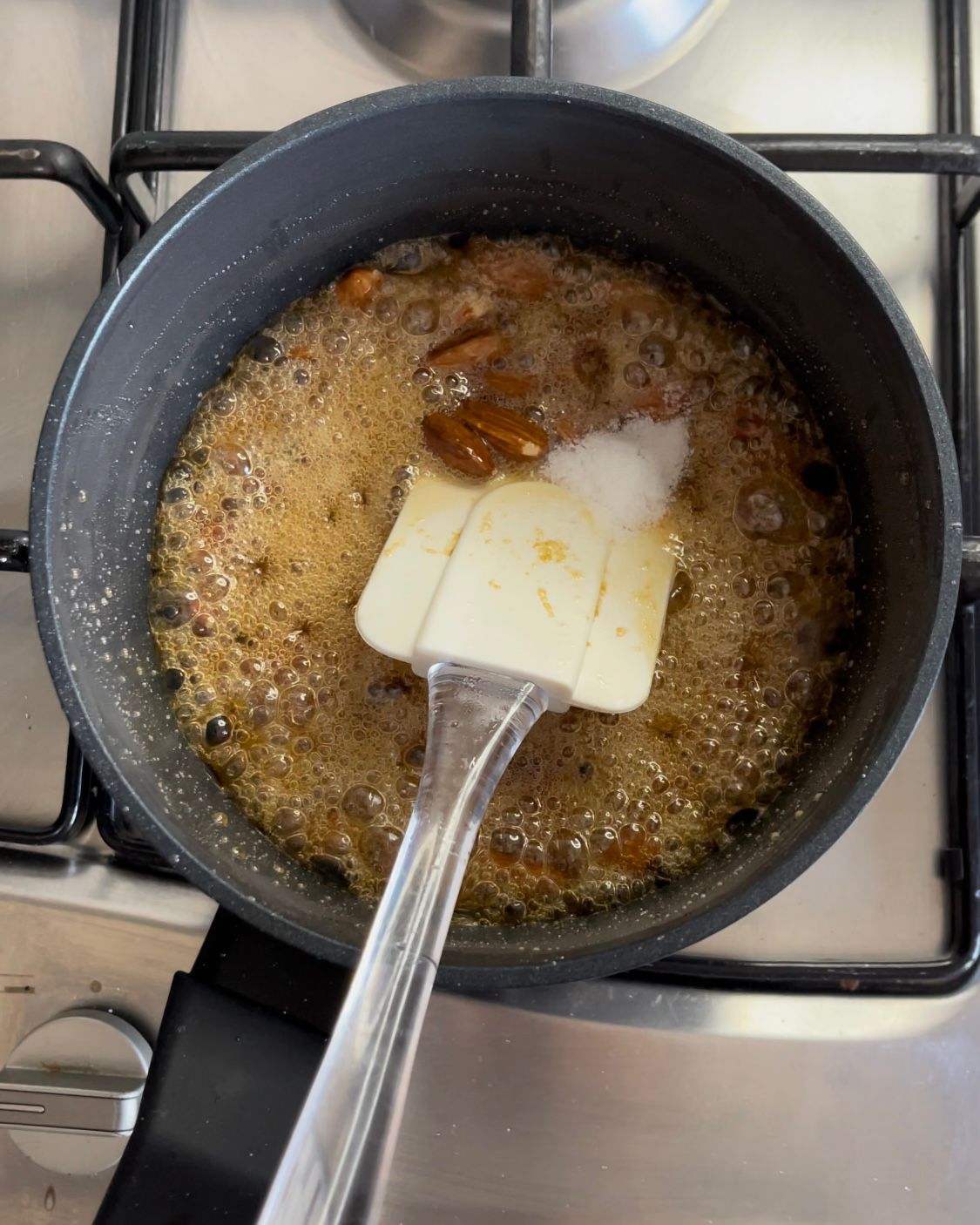 Una spatola è in una pentola piena di liquido sul fornello.