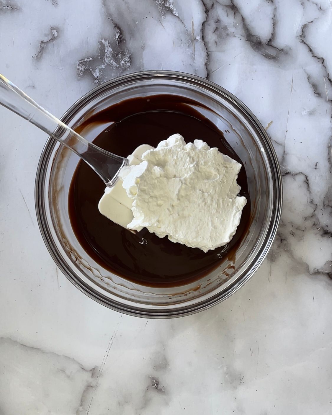 Una ciotola di cioccolato e panna montata con una spatola dentro