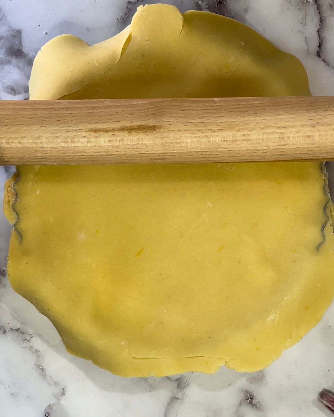 Si stende la pasta per torta con un mattarello di legno.