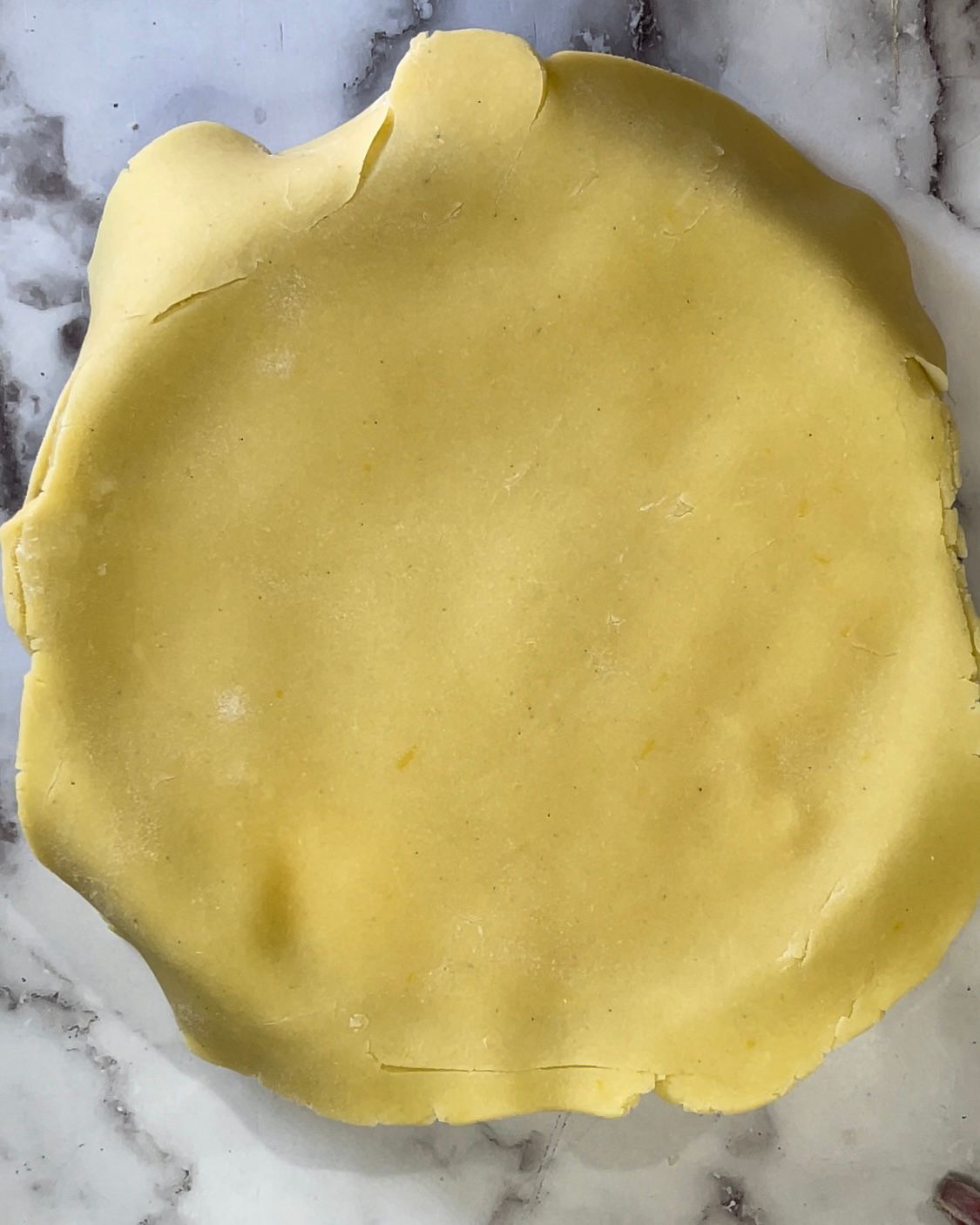Un pezzo di pasta è appoggiato su una superficie di marmo.
