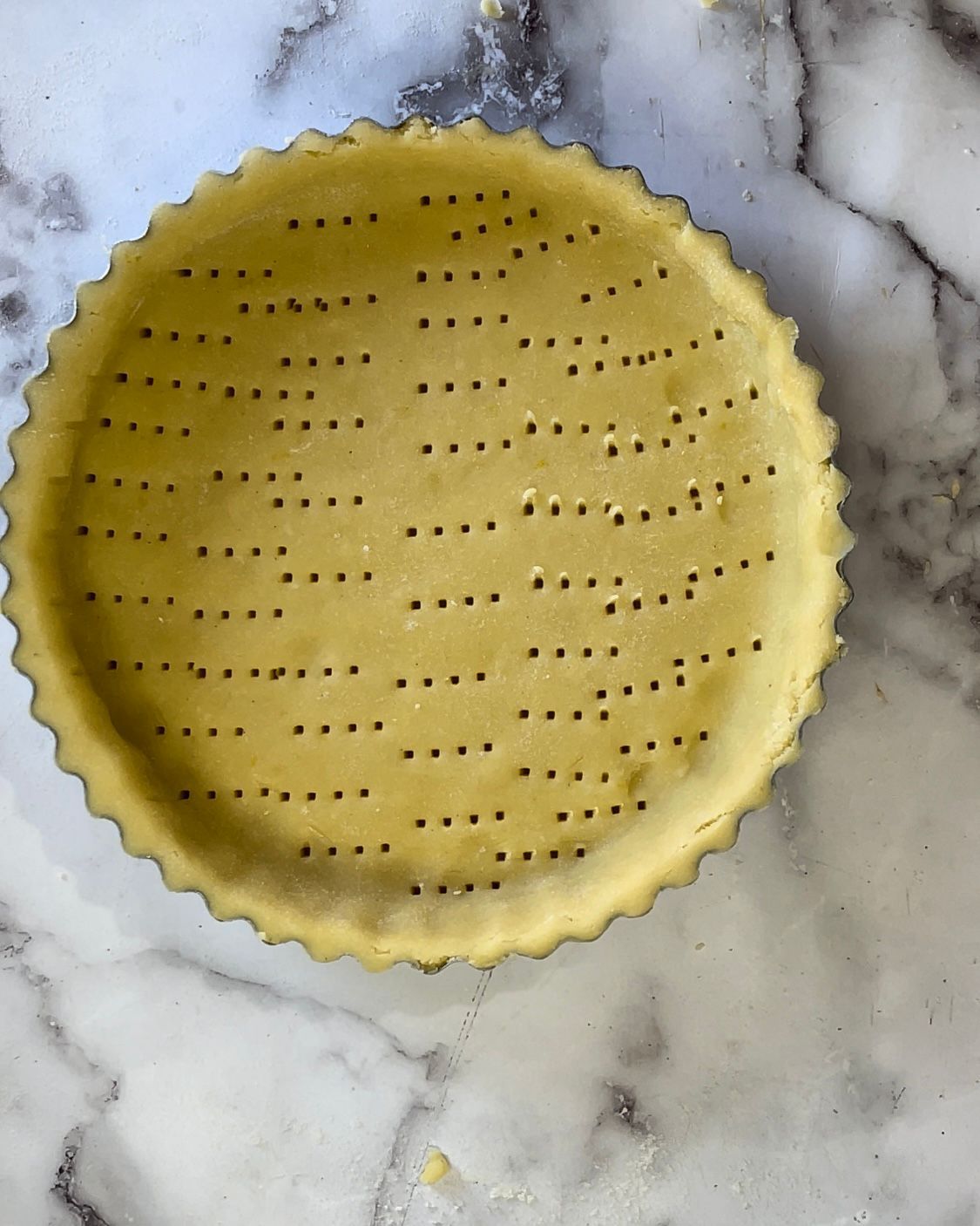 Una crosta di torta è appoggiata su una superficie di marmo