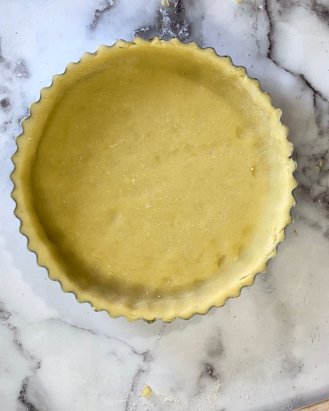 Una crosta di torta è appoggiata su una superficie di marmo.