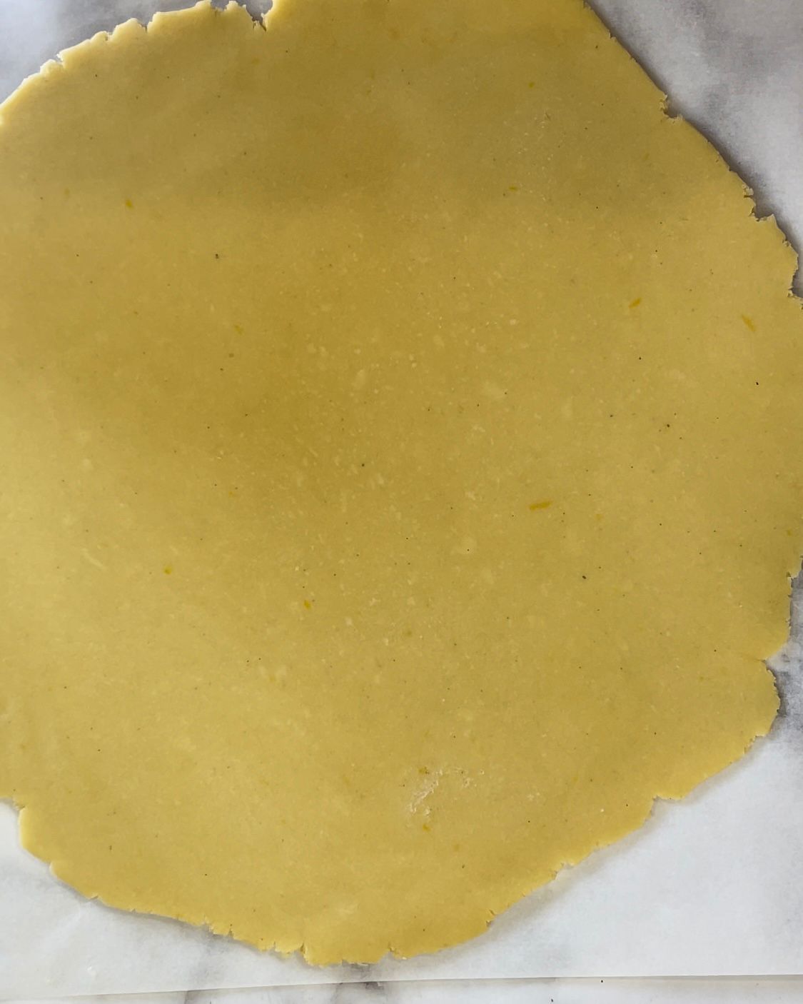 Un pezzo di pasta è appoggiato su una superficie di marmo.
